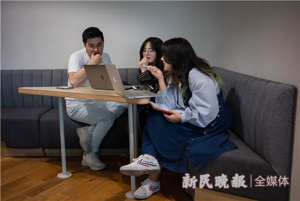 图说：公司成员在联合办公楼走廊的一个小角落里谈论视频拍摄的问题。