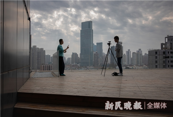 图说：大鱼（左）和公司视频摄影师在楼顶拍摄。