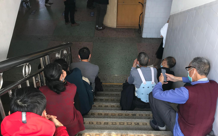 11月18日，社港医院门诊大厅旁等待的患者和家属。新京报记者 张惠兰 摄