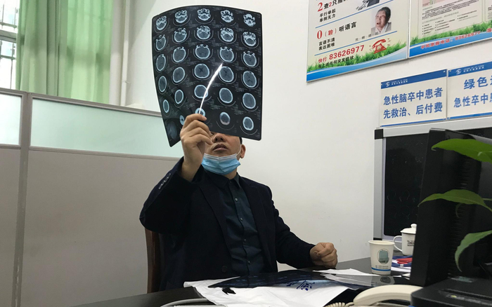 11月27日，贝玉章在诊室查看患者的CT片。新京报记者 张惠兰 摄