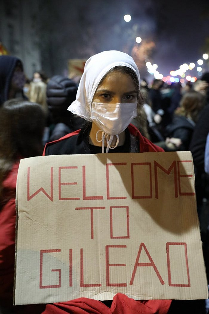 当地时间10月23日，波兰华沙，一位女性穿着使女的服装反对最新出台的堕胎法案。（图片来源：TheConversation）