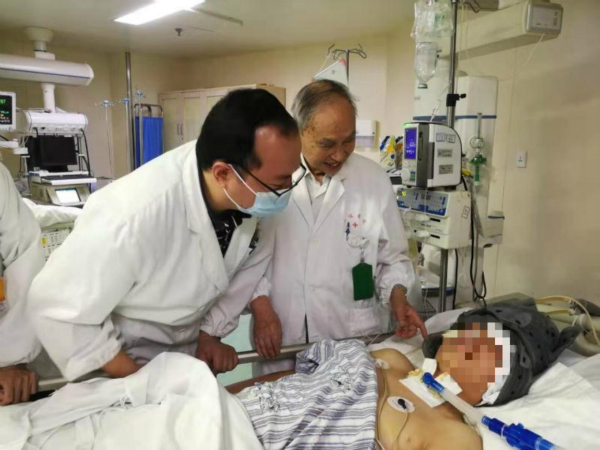 图说：在长征医院ICU接受治疗的小袁，景炳文教授和何超医生试图和他交流
