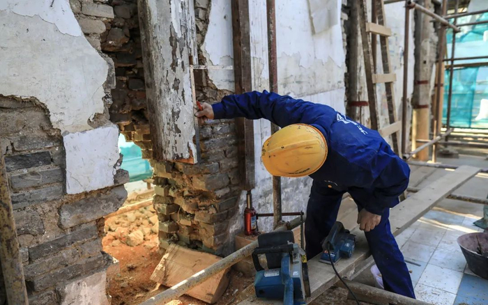 ▲11月10日，施工工人正在测量旧柱子接口的尺寸。新京报记者 浦峰 摄