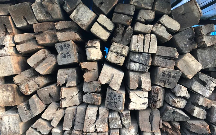 ▲11月24日，万寿寺东路施工现场，替换下来的老木构建被堆放在一起，并标注了来源。新京报记者 韩沁珂 摄