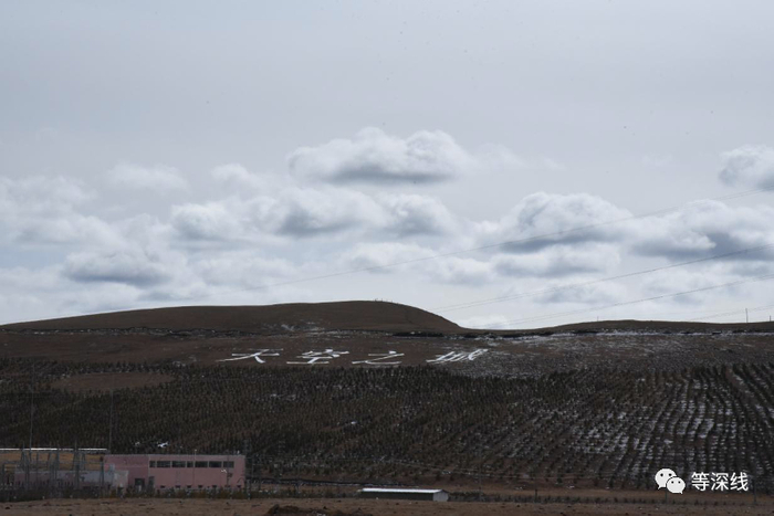 &nbsp;理塘县外的山坡上，写有“天空之城”的标语。《等深线》记者&nbsp;郑丹 摄