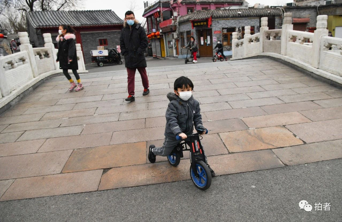 △ 3月2日，小朋友骑自行车经过什刹海银锭桥。摄影/新京报记者李木易