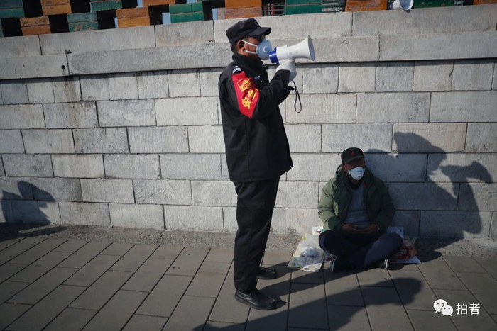 △ 3月7日，景山公园，工作人员提醒游客少停留、少聚集。摄影/新京报记者侯少卿