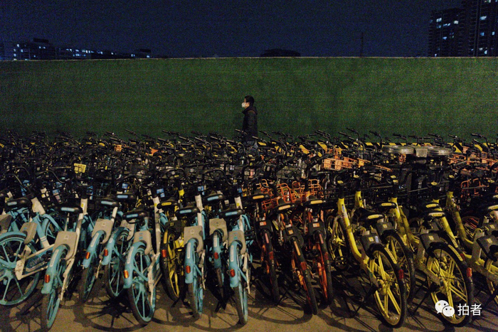 △ 2月25日晚，朝阳区望京，市民从共享单车群旁走过。摄影/新京报记者郑新洽