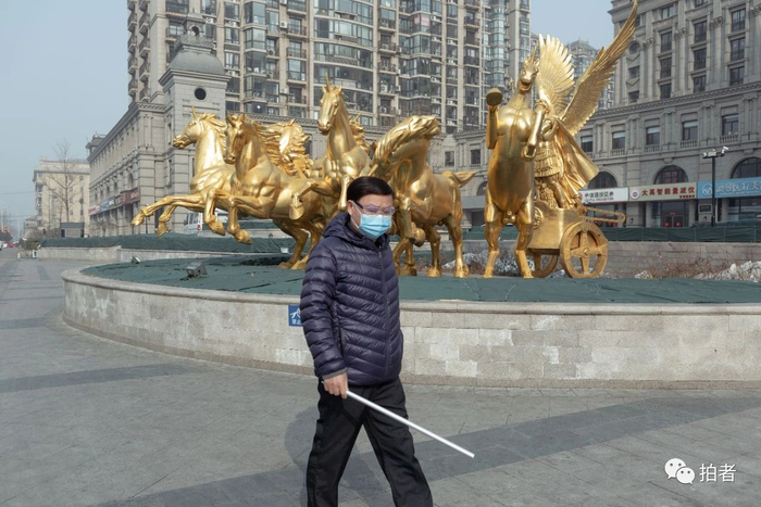 △ 2月11日，西大望路附近，佩戴口罩和护目镜的行人。摄影/新京报记者陈婉婷