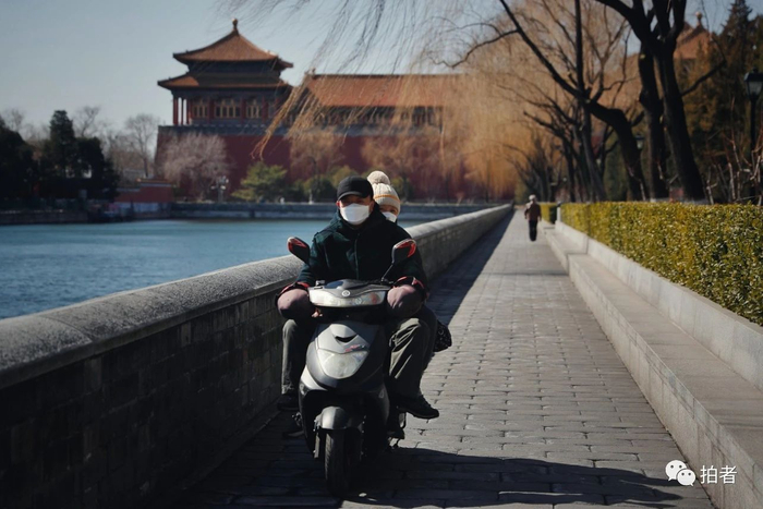 △ 3月3日，东华门路，市民戴着口罩骑电动车出行。摄影/新京报记者侯少卿