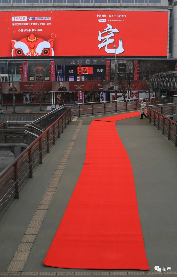 △ 2月13日，西单，戴口罩的市民经过曾经门庭若市的商区。摄影/新京报记者浦峰