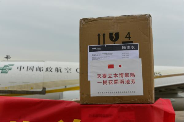  浙江向日本静冈县政府捐赠物资贴着“天台立本情无隔，一树花开两地芳”的标识。
