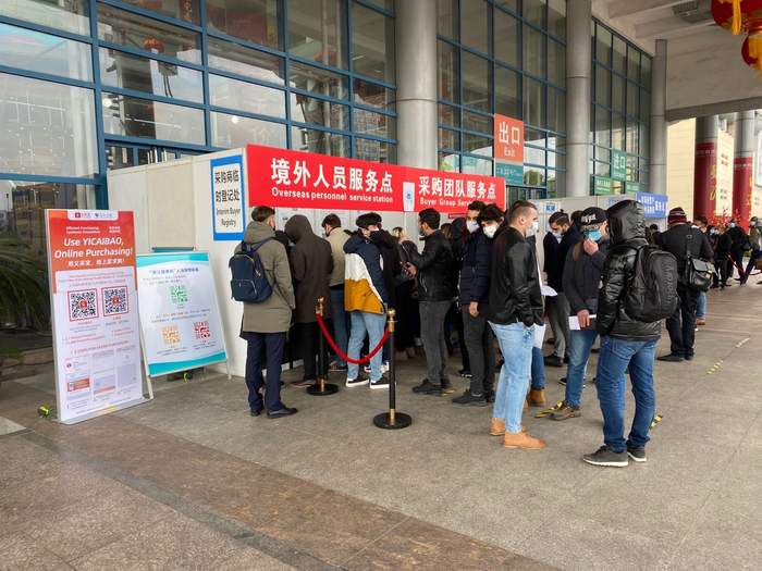 境外客商戴口罩准备登记后进入市场采购。