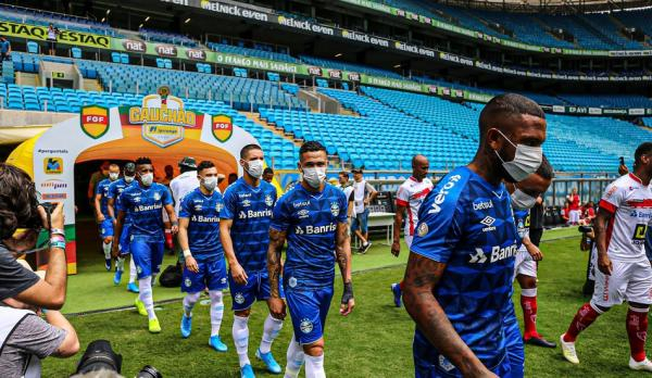  巴西格雷米奥队球员戴口罩入场比赛。