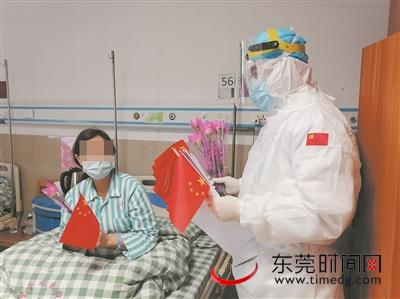 ▲钟汉平给女患者送小国旗和鲜花，祝她们早日康复 医院供图