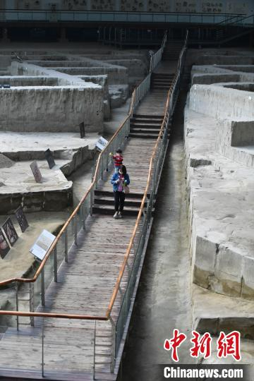 成都金沙遗址博物馆遗迹馆内，游客戴口罩有序参观。　张浪 摄