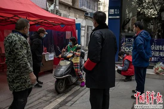 　　2月17日，湖北省孝感市三里棚社区第六网格，社区工作人员在询问一名打算出社区的居民。中青报·中青网记者&nbsp;李隽辉/摄