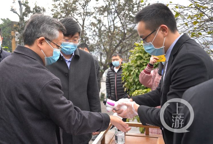 副市长李波（左一）来到火锅店门口，按照火锅店要求依次测量体温。