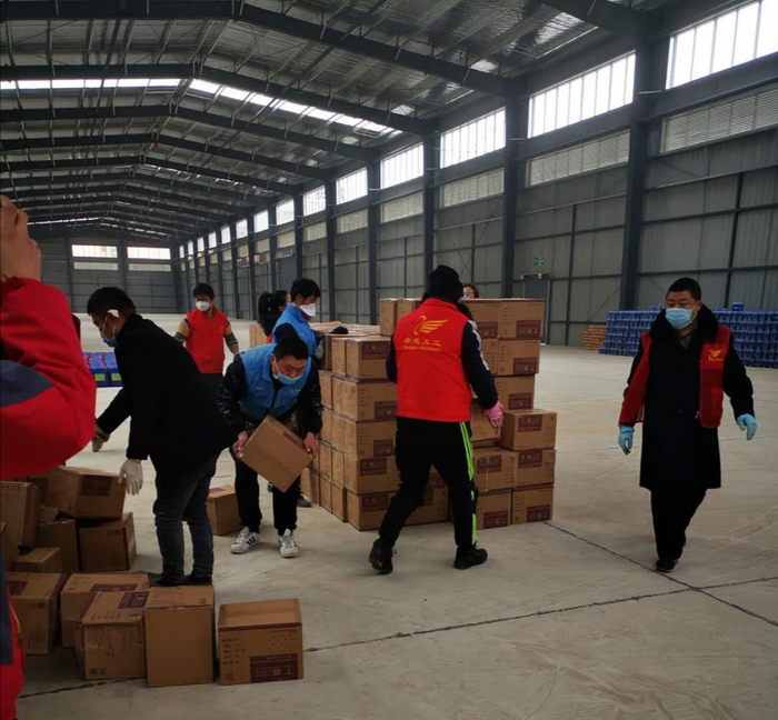 货车司机把运输应急物资送到目的地，前来装卸物资的都是湖北当地的志愿者。