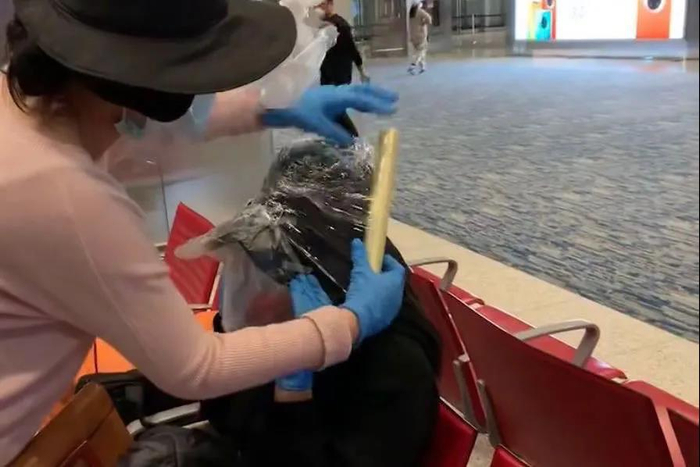 中国留学生将塑料膜缠在帽子上，做好防护。/ 受访者供图