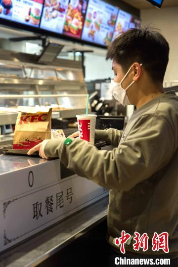 在肯德基餐厅内，进店就餐顾客按号无接触取餐。　沙见龙 摄