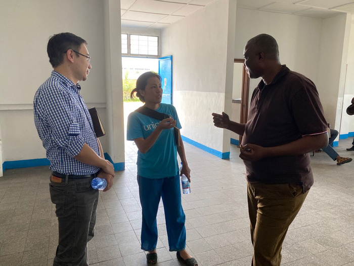  唐昆（左）向当地卫生部门官员了解情况