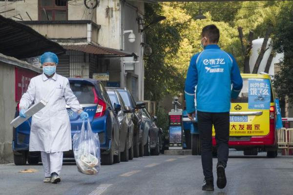  2020年1月31日，在武汉市第五医院，快递小哥与一名医护人员擦肩而过。 新华社 资料&nbsp;