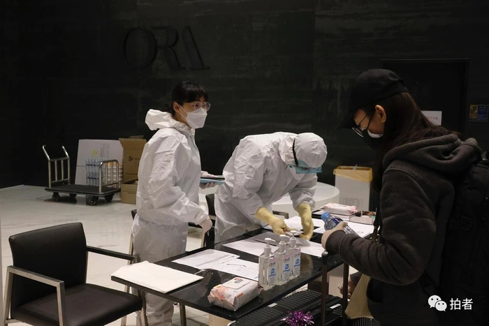 △&nbsp;当地时间3月24日凌晨，ORA酒店大堂，身着防护服的工作人员为隔离人员分配房间。