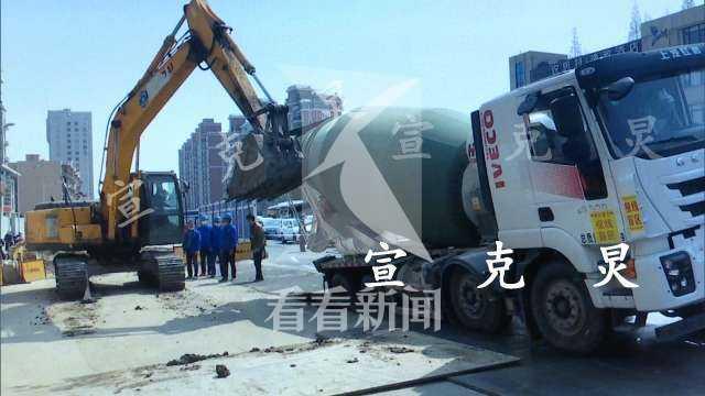 混凝土搅拌车疑在刚浇灌的路上卸料 车轮陷入路面