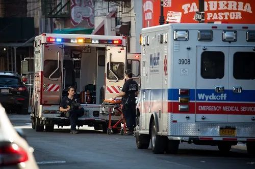 ▲4月6日，在美国纽约一家医院外，医护人员在救护车旁待命。新华社发