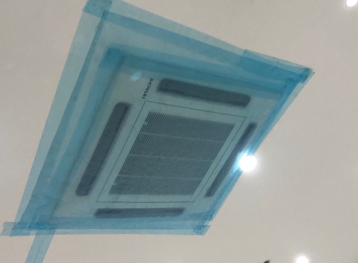  施工人员已用塑料布和胶带封住了空调口。