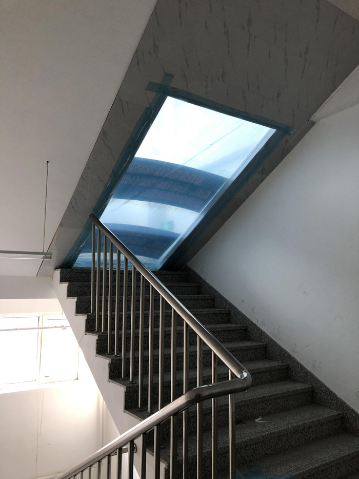  绥芬河方舱医院楼梯通道五层半，施工方用PVC板和塑料布进行封堵，防止气体流通。