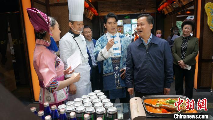 图为桂林市长秦春成向网友推荐桂林特色菜肴啤酒鱼。　欧惠兰 摄