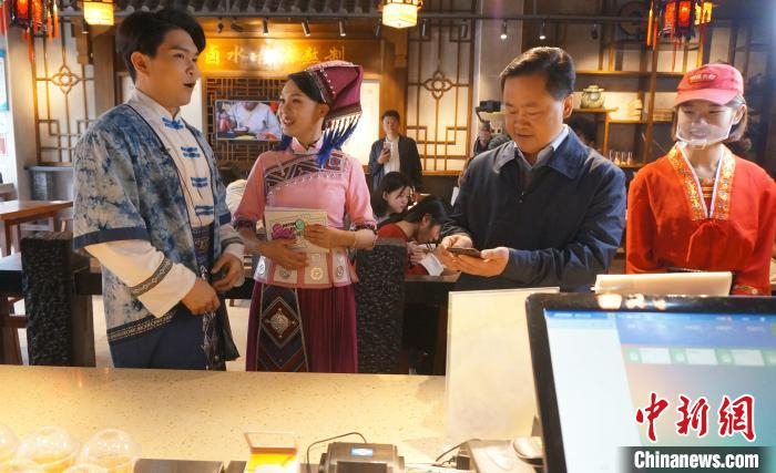     图为桂林市长秦春成（右二）用手机扫码，带头消费。　欧惠兰　摄