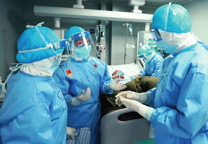 3月17日，武汉火神山医院，重症医学一科护士长陈静（中）与医生讨论患者病情 王毓国摄 / 本刊