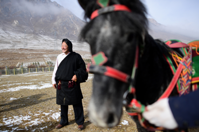　　青海省玉树藏族自治州玉树市扎西大同村三社社长才哇在扎西科赛马场上观看村民训练马匹（4月3日摄）。新华社记者 张宏祥 摄