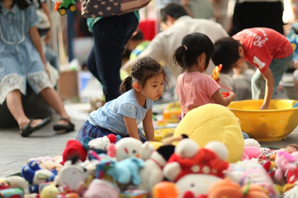 在玩具山中寻找喜欢的玩偶的孩子