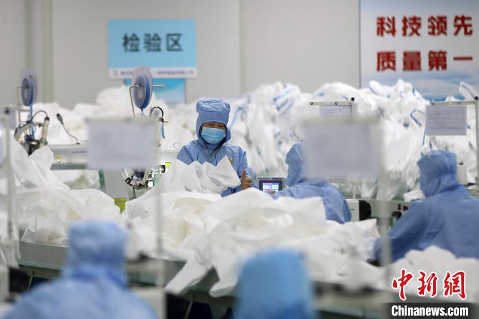 工人们正在生产制作防护服。　泱波 摄