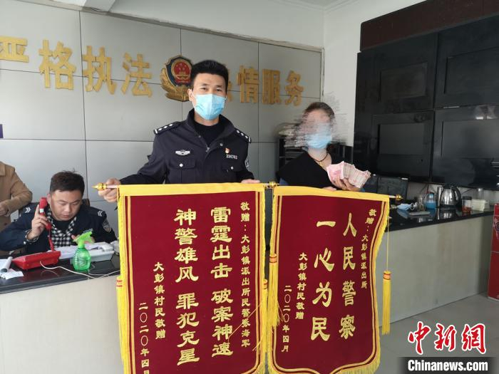     受害人领回被骗钱款，送上锦旗致谢。铜山区公安局供图
