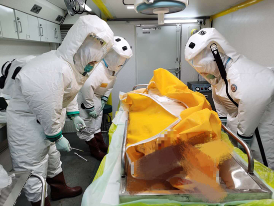 火神山医院的负压尸检方舱内，研究团队向捐献者遗体致敬。火神山医院供图