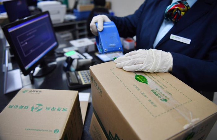 工作人员在使用宽度在45毫米以下的“瘦身”胶带包装货物。摄 新京报记者 李木易