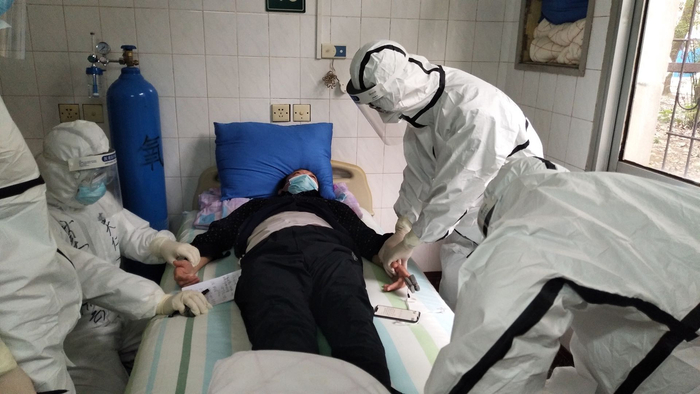 莫仁云（左）和其他医护查看、记录患者病情