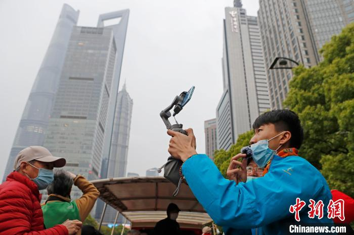 摄影爱好者在“都市观光”巴士车顶，拍摄上海城市并网络直播。　殷立勤 摄