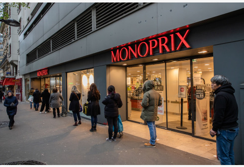 3月21日，在法国巴黎，人们在一家超市外保持间距排队。 新华社 图