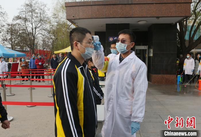 班主任用额温枪测试学生体温。　崔广义供图