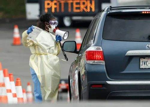 　　3月19日，在美国弗吉尼亚州阿灵顿，医护人员在一处“免下车”新冠肺炎检测点引导车辆。新华社发（沈霆摄）