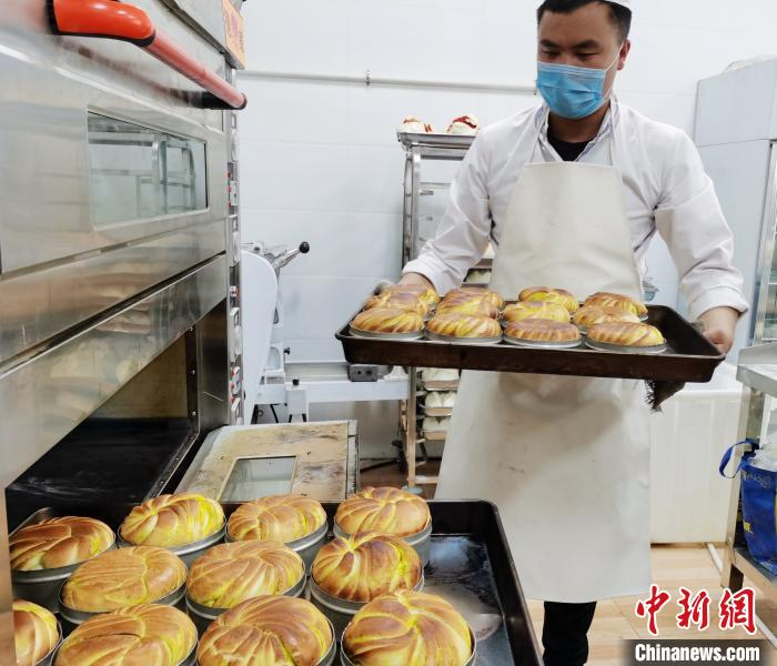     图为馍馍师傅从电烤箱里端出锟锅。　张添福　摄