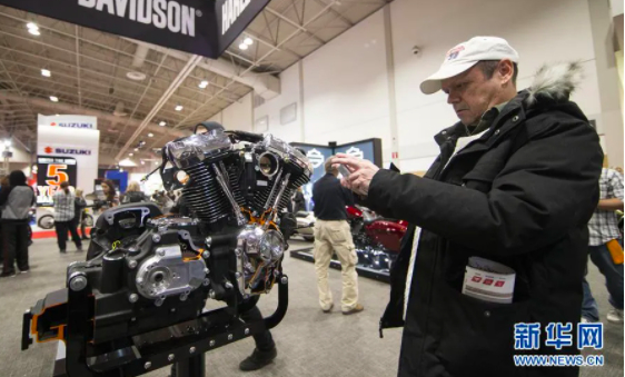 　　△一名摩托车爱好者在摩托车展上拍摄哈雷摩托车的发动机。新华网发
