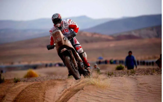 　　△车手驾驶摩托车在比赛中。新华社发