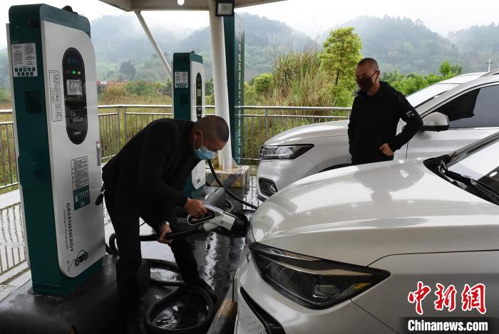     图为市民正在高速公路服务区充电站为车辆充电。　周毅　摄